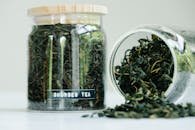 Herbal tea leaves in glass jars showcasing natural ingredients and traditional style.